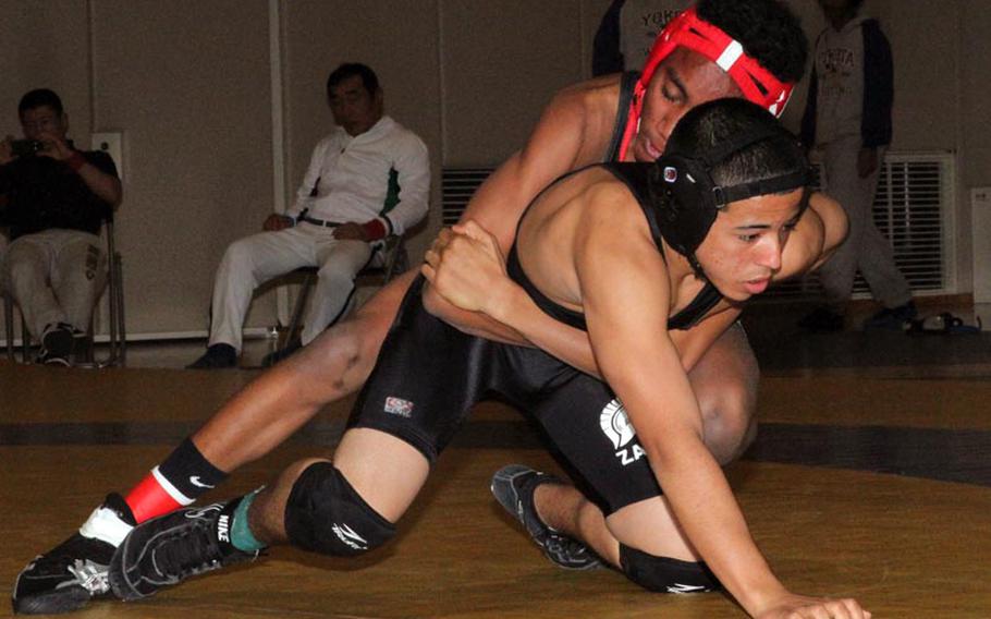 Nile C. Kinnick 115-pounder Quincy McCants gets the upper hand on Zama American's Eric Otero during Saturday's Kanto Plain Association of Secondary Schools wrestling finals at St. Mary's International School, Tokyo. McCants won a two-period decision 8-0 and 6-1.