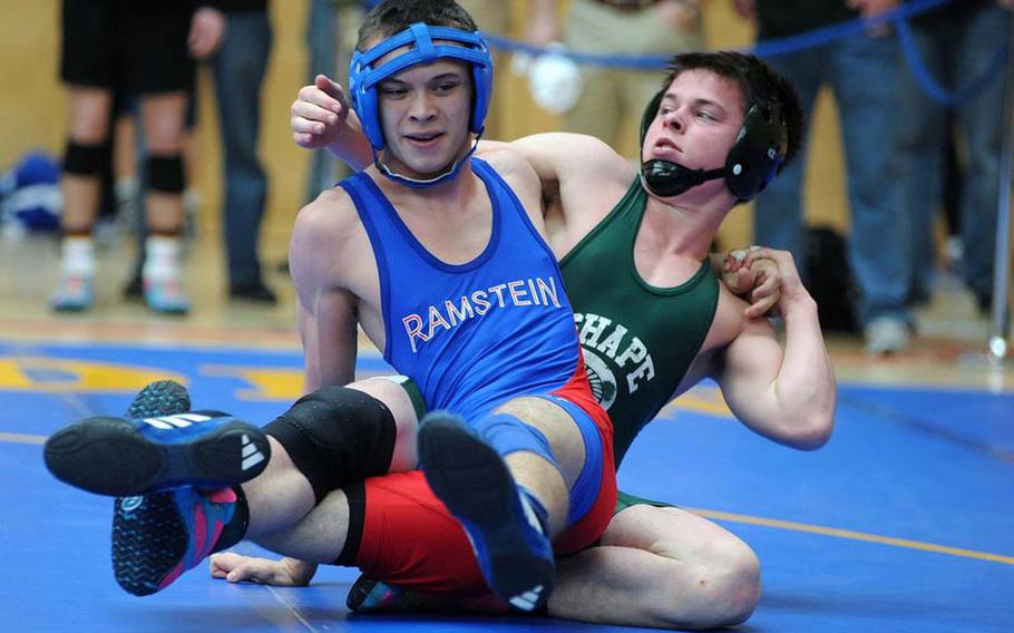 Ramstein's T.J. Moore and SHAPE's Matt Lengyel grapple in a 132-pound match on opening day of the DODDS-Europe wrestling championships in Wiesbaden, Friday. Lengyel won on a tech-fall at 3:33.