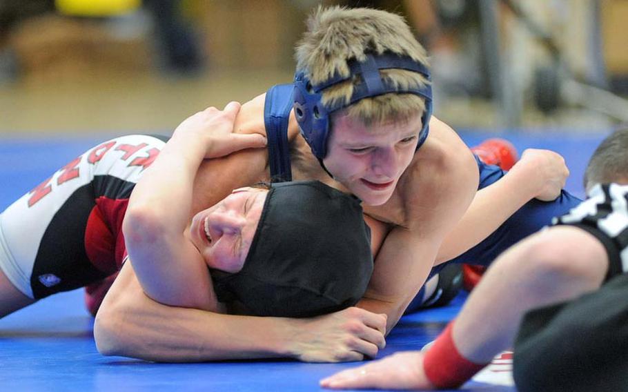 Black Forest Academy's Victor Baart puts the pressure on Kaiserslautern's Ashleigh Gagnon for a pin in their 113-pound match on opening day of the DODDS-Europe wrestling championships.