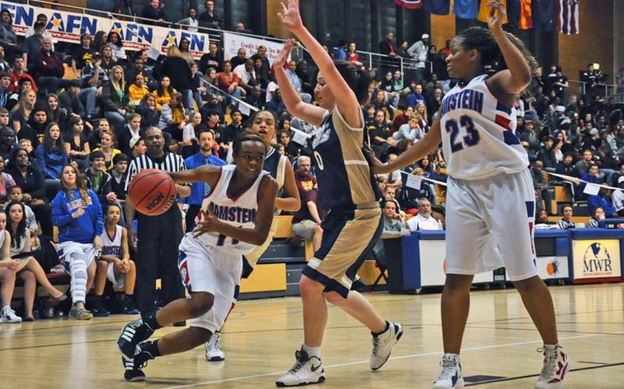 Ramstein's Samia Ladner takes it to the hoop as Heidelberg's Emma Roberts defends and teammate Jasmine Young looks on, during the Division I championship game Saturday in Wiesbaden, Germany. Heidelberg won the game 32-31.