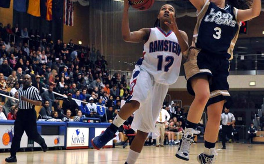 Ramstein's Diamond Allen goes up for a layup as Heidelberg's Kylee Miller attempts a block during the Division I championship game Saturday in Wiesbaden, Germany. Heidelberg won the game 32-31.