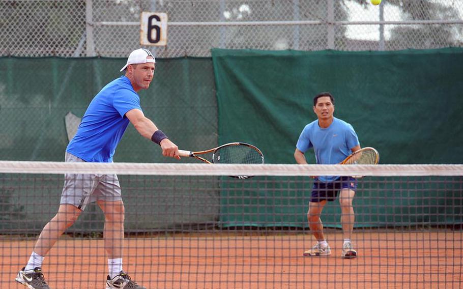 Michael Stuber, left, returns a ball in the third place men's doubles match at the U.S. Forces-Europe tennis finals in Heidelberg, Germany, Saturday, as partner Michael Mejia watches. They lost the match to Nate Strong and Kirk Madgic 6-7 (7-5), 6-3 and 10-4 in the championship tiebreaker.