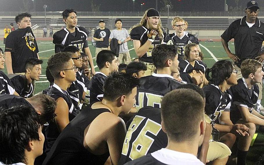 Elayna Snyder, third from right, takes a knee in the Humphreys football team huddle following the Blackhawks' 13-11 win over Kubasaki of Okinawa. Snyder kicked the point-after following Humphreys' first of two touchdowns.