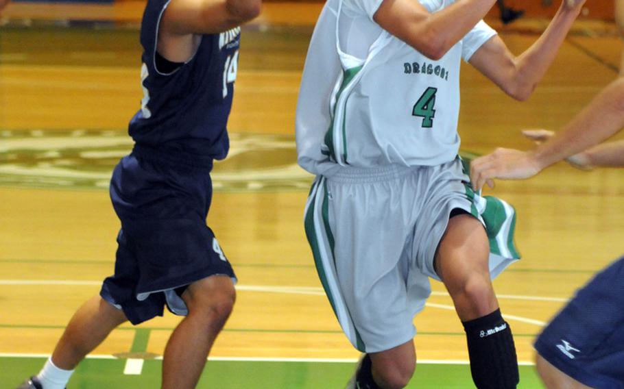 Kubasaki guard B.J. Simmons drives past Kitanakagusuku's Ryo Uema to the basket during Tuesday's boys high school basketball game at Camp Foster, Okinawa. The host Dragons beat the Fighting Lions 81-68.