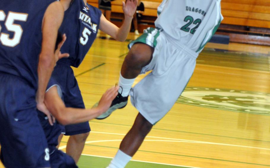 Kubasaki guard C.J. Crenshaw puts up a shot past Kitanakagusuku's Nizuki Teruya, left, and Leon Shiroma during Tuesday's boys high school basketball game at Camp Foster, Okinawa. The host Dragons beat the Fighting Lions 81-68.