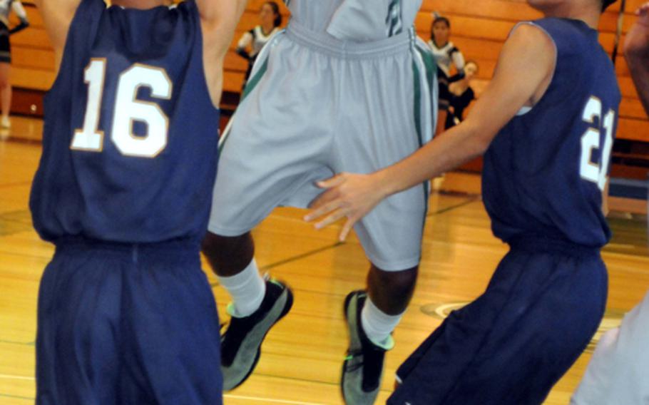 Kubasaki guard C.J. Crenshaw drives to the basket between Kitanakagusuku's George Nakasone, left, and Narikazu Uehara during Tuesday's boys high school basketball game at Camp Foster, Okinawa. The host Dragons beat the Fighting Lions 81-68.