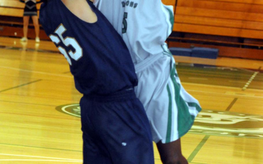 Kubasaki forward Xavier Price plows into Kitanakagusuku's Nizuki Teruya during Tuesday's boys high school basketball game at Camp Foster, Okinawa. The host Dragons beat the Fighting Lions 81-68.