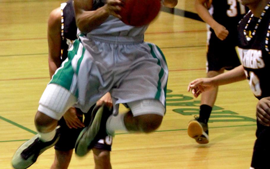 Kubasaki's C.J. Crenshaw puts up a shot against three Kadena defenders during Thursday's Okinawa Activities Council boys basketball season series finale at Kubasaki High School. The Dragons beat the Panthers 76-67 and won the season series 3-1.