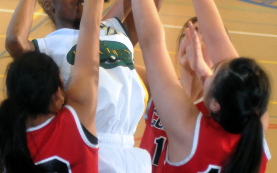 Xala Sledge of Robert D. Edgren shoots against three E.J. King defenders during the girls opening game in the 2012 DODDS Japan basketball tournament at Yokota High School. The Eagles beat the Cobras 47-41.