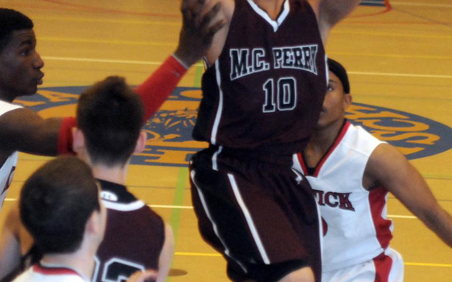 Jon Cadavos (10) of Matthew C. Perry shoots between three Nile C. Kinnick defenders during the boys opening game in the 2012 DODDS Japan basketball tournament atYokota High School. The Red Devils beat the Samurai 64-43.