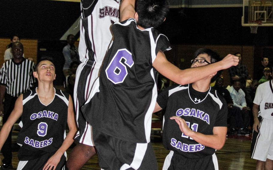 Matthew C. Perry's Jarell Davis shoots over Senri-Osaka International defender Kan Sawabe during Friday's boys high school basketball game at Marine Corps Air Station Iwakuni, Japan. The Samurai beat the Sabres 53-38.