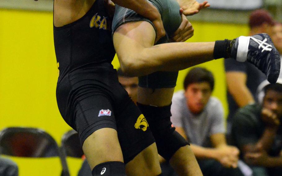 In a battle of former Far East champions, Kadena's Justin Duenas lifts Kubasaki's Daniel Mora in the 115-pound bout during Wednesday's Okinawa Athletics and Activities Council high school wrestling meet at Kadena Air Base, Okinawa. Mora rallied from a 10-5 deficit to win the bout 15-10 over Duenas, who injured his back on this lift. Kubasaki won the dual meet 42-16.