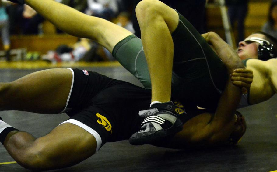 Kadena's Jason Bland tilts Kubasaki's Christian Rutledge for two points in the 129-pound bout during Wednesday's Okinawa Athletics and Activities Council high school wrestling meet at Kadena Air Base, Okinawa. Bland won by technical fall 8-0 in 2:03, but Kubasaki won the dual meet 42-16.