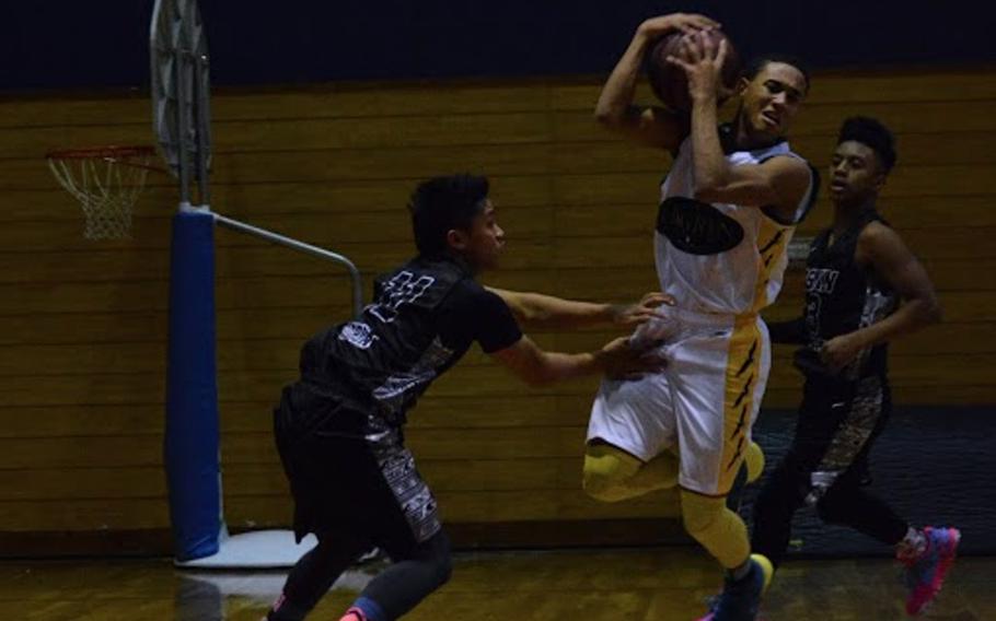 Osan's Sean Copia and Nicholas White guard Edgren's Shawn Ortiz-Robinson as he catches a ball with his head Tuesday during a Far East tournament game.