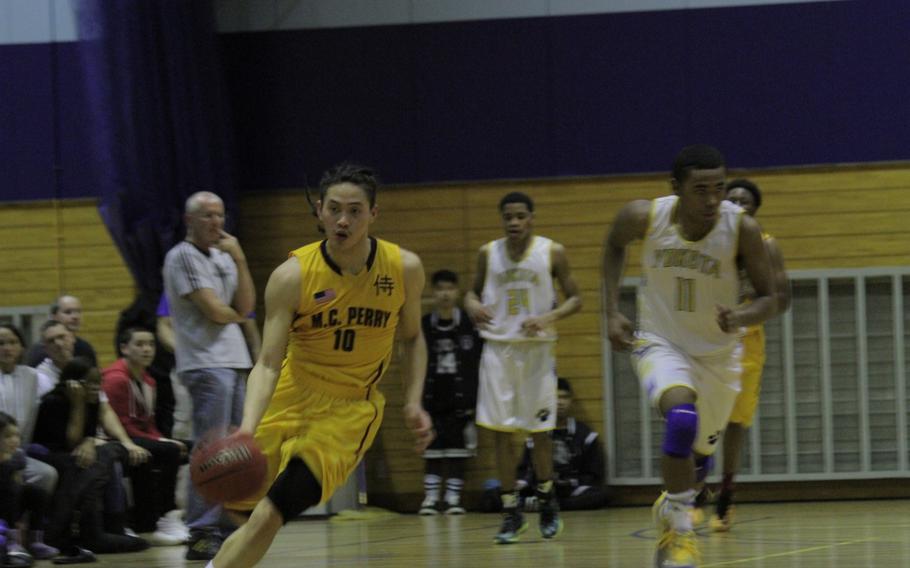 Matthew C. Perry's Jon Cadavos dribbles the ball up the court Tuesday during a double-elimination playoff game against Yokota at the Far East basketball tournaments. Perry won 71-62.