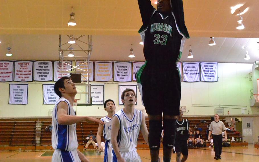 Kubasaki's Matt Ashley looks to score against Christian Academy Japan's Joshua Turner and Riki Kurihara.
