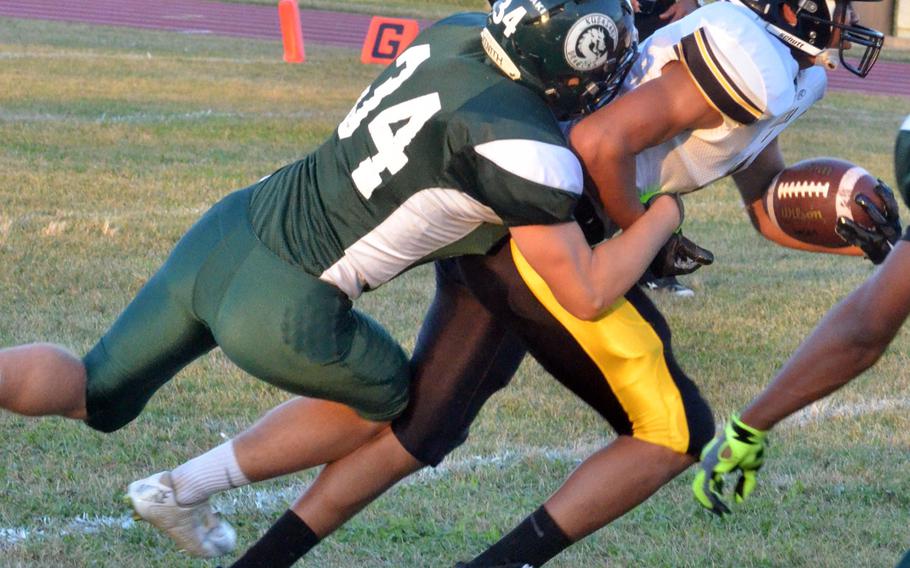 Kadena receiver Donte Savoy gets wrapped up by Kubasaki's Timothy Rivers.