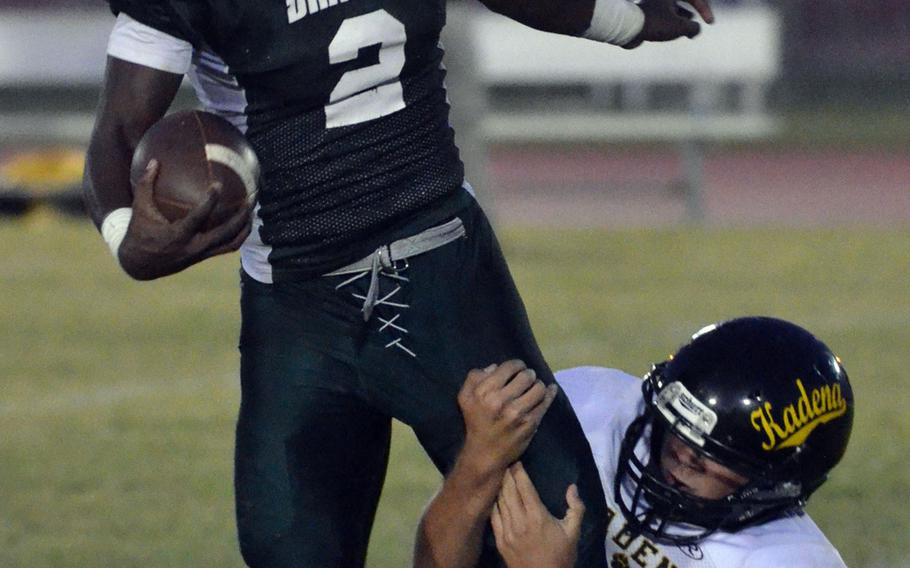 Kubasaki QB Isaiah Johnson tries to elude the clutches of Kadena's Keagan Longtin.