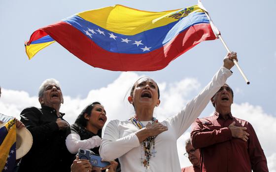 Opposition leader Maria Corina Machado waves a Venezuelan national flag during a rally in Venezuela.