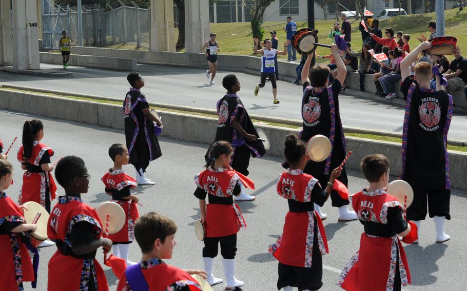 Amelia Earhart Intermediate School students play taiko drums and cheer on runners during the 2015 Okinawa Marathon on Kadena Air Base, Japan, Feb. 17, 2013. More than 400 servicemembers, civilians, family members, and private organizations of Kadena supported the event by volunteering to hand out water and cheer on participants.