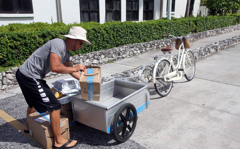 Antti Koski loads up his bike wagon with packages in front of the Kwajalein post office. With few retail stores on the small island, online shopping is a lifeline for residents.
