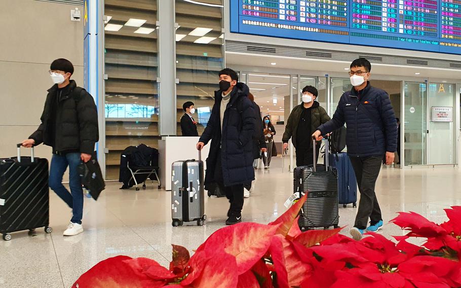 Airplane passengers exit an arrival gate wearing masks at Incheon International Airport, South Korea, Monday, Feb. 3, 2020.


