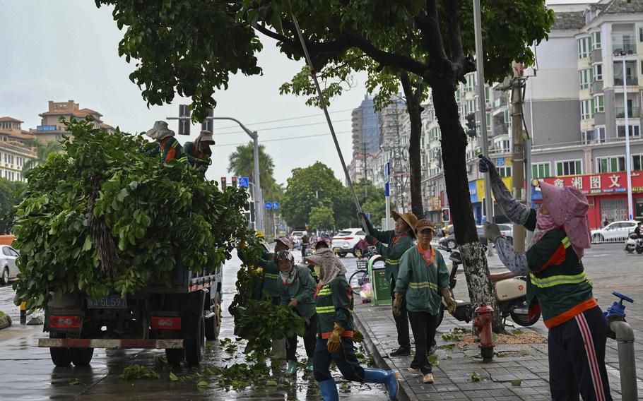 In this image released by Xinhua News Agency, workers cut redundant branches off of trees along a street ahead of the landfall of typhoon Yagi in Haikou, south China's Hainan Province, Thursday, Sept. 5, 2024. 