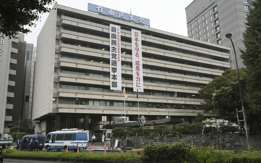 Police vehicles park near the headquarters of Japan's ruling Liberal Democratic Party in Tokyo after a man threw firebombs into the headquarters Saturday, Oct. 19, 2024. 