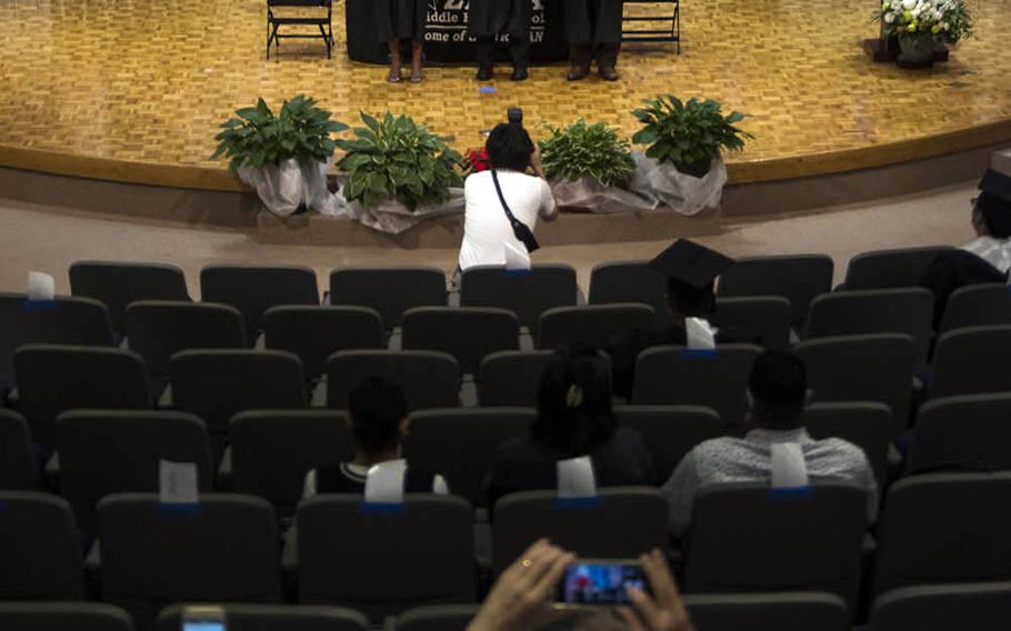 A senior poses with his diploma during a graduation ceremony at Zama American Middle High School at Camp Zama near Tokyo, Wednesday, June 3, 2020.