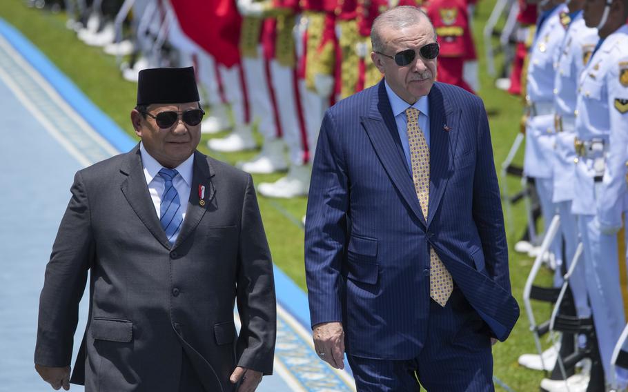 Two foreign officials walk during a ceremony in Indonesia.