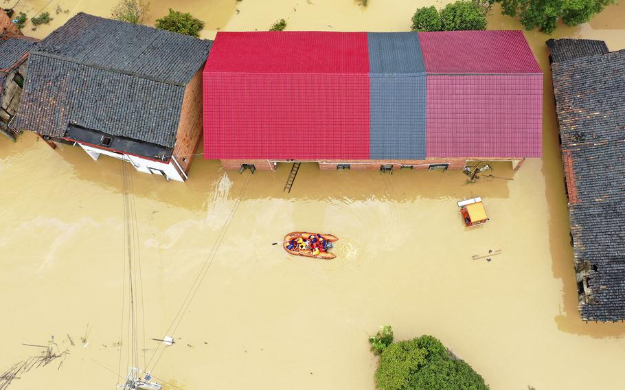 Rescuers use a dinghy boat to evacuate villagers trapped by floodwaters in Jingtang village, Zixing city, in southern China's Hunan province, on July 28, 2024. 