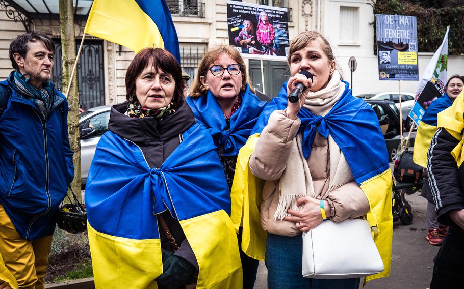 People carry flags on a street in France.