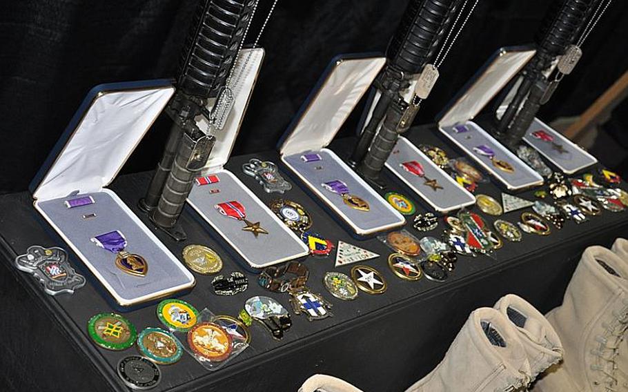 Bronze Star Medals, Purple Hearts and unit coins are laid out at the memorial service Wednesday in Hohenfels, Germany, for Staff Sgt. Joshua A. Throckmorton, Spc. Jordan C. Schumann and Spc. Preston J. Suter. The soldiers were killed July 5 by a bomb in Afghanistan, according to a Defense Department news release.