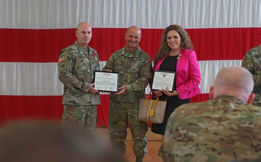 Col. David Shank, center, and his wife Myrna receive awards from Lt. Gen. Christopher Cavoli before the 10th Army Air and Missile Defense Command change of command ceremony at the Kleber Kaserne gym in Kaiserslautern, Germany, Aug. 7, 2019. Shank received the Legion of Merit award and his wife received the Meritorious Public Service Medal for her service to the 10th Army Air and Missile Defense Command community.