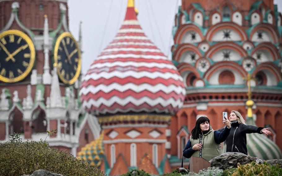 People make selfie photo in front of the Kremlin's Spasskaya tower and St. Basil's cathedral in downtown Moscow on Nov. 10, 2023. Matthew Olsen, assistant attorney general for national security, said at an event at Columbia Law School in New York on Thursday that Russia, Iran and China are “ramping up” attempts to stoke divisions within the U.S. ahead of November’s presidential election.