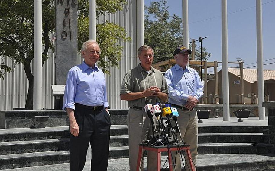 A memorial commemorating victims of the 9/11 terrorist attacks served as a backdrop for a visit to Bagram Airfield in eastern Afghanistan on Independence Day by, from left, U.S. Senators Joe Lieberman, Lindsey Graham and John McCain.