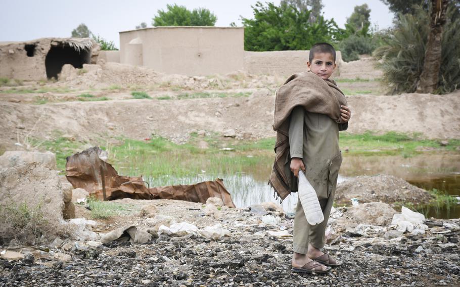 A child plays alongside a quagmire created by an American airstrike on the outskirts of Lashkar Gah, provincial capital of Helmand, April 14, 2019. Locals said Americans had bombed the area, known to be a Taliban stronghold, after militants had overrun much of Helmand province in 2015.
