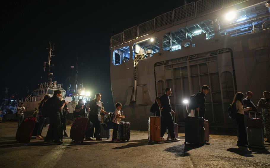 Turkish citizens walk to board Turkish military ships evacuating them from Lebanon to Turkey, in Beirut port on Wednesday, Oct. 9, 2024. 