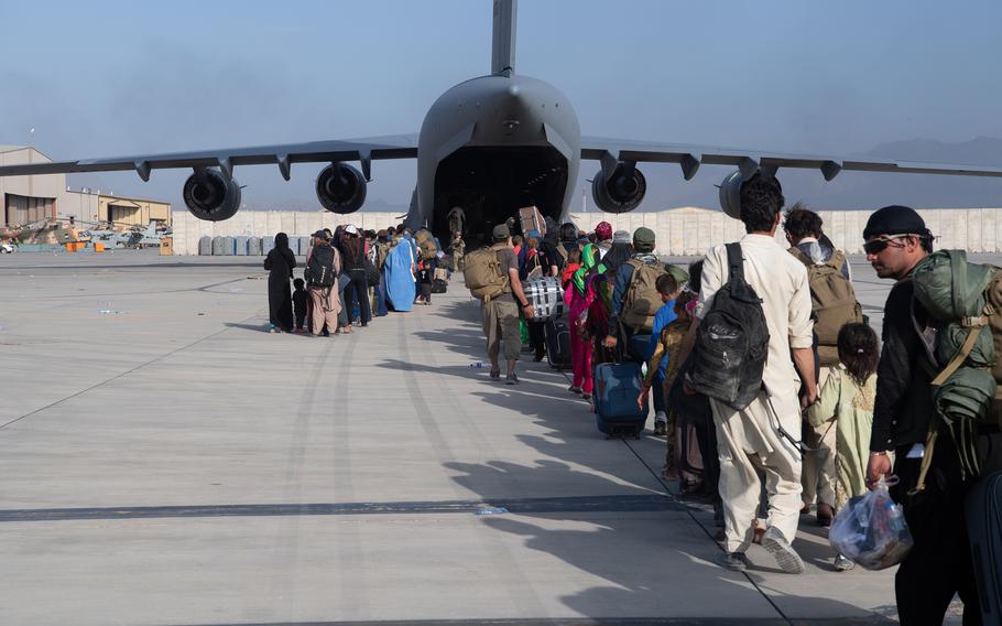 In a handout image provided by U.S. Central Command Public Affairs, U.S. Air Force loadmasters and pilots assigned to the 816th Expeditionary Airlift Squadron, load passengers aboard a U.S. Air Force C-17 Globemaster III in support of the Afghanistan evacuation at Hamid Karzai International Airport on Aug. 24, 2021, in Kabul, Afghanistan. 