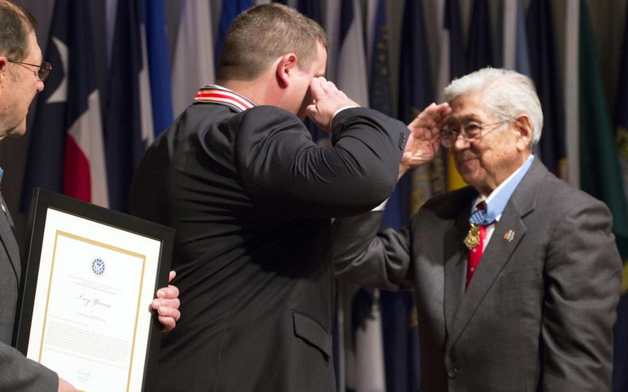 Citizen Honors award recipient Troy Yocum and Medal of Honor recipient Hiroshi Miyamura exchange salutes during a ceremony at Arlington National Cemetery on Medal of Honor Day, March 25, 2014.