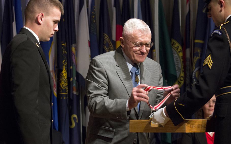 Medal of Honor recipient Wesley Fox prepares to present the Citizen Honors award to Connor Stotts during a ceremony at Arlington National Cemetery on Medal of Honor Day, March 25, 2014.