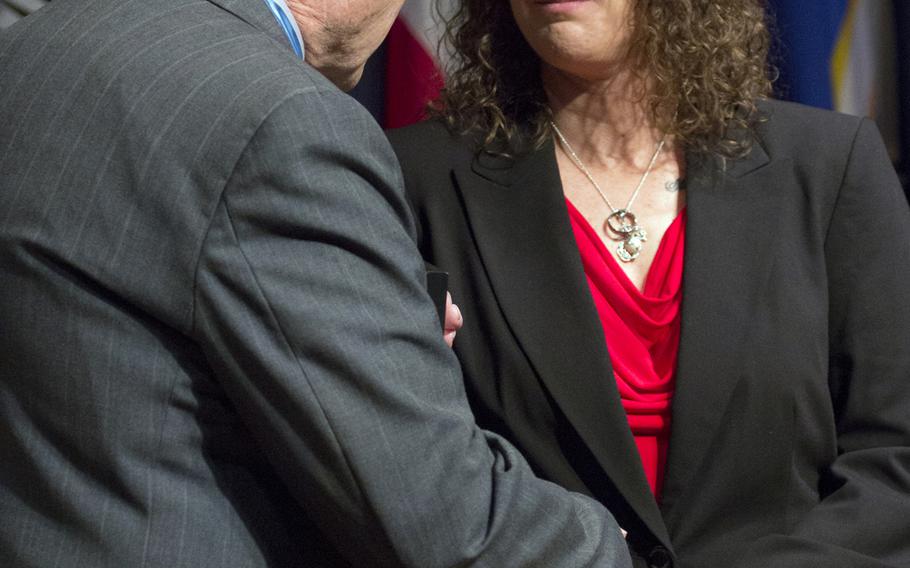 Medal of Honor recipient Harold Fritz shakes hands with Sharon Landsberry after presenting her with the Citizen Honors award on behalf of her late husband, Michael, during a ceremony at Arlington National Cemetery on Medal of Honor Day, March 25, 2014.