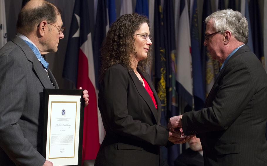 Medal of Honor recipients Harold Fritz, left, and Thomas Kelley present the Citizen Honors award to Sharon Landsberry on behalf of her late husband, Michael, during a ceremony at Arlington National Cemetery on Medal of Honor Day, March 25, 2014.