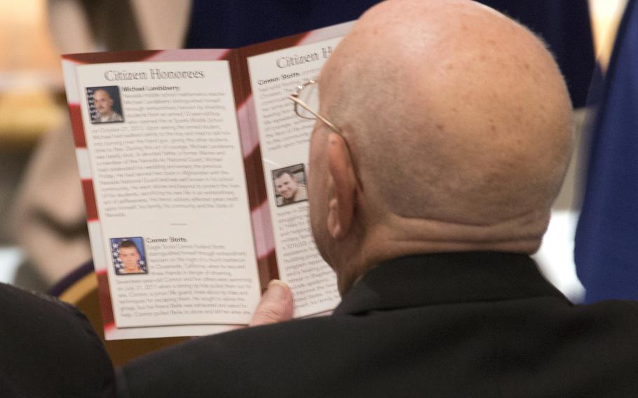 Medal of Honor recipient Hershel Williams reads the program while awaiting the start of the Citizen Honors award ceremony at Arlington National Cemetery on Medal of Honor Day, March 25, 2014.