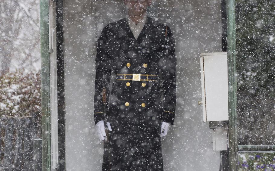 Snow falls during the wreath-laying ceremony at Arlington National Cemetery on Medal of Honor Day, March 25, 2014.