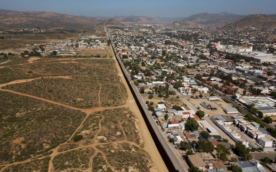 An aerial image shows the U.S.-Mexico border between San Diego County and the Mexican city of Tecate, Baja California, (right) on May 10, 2021, in Tecate, California.