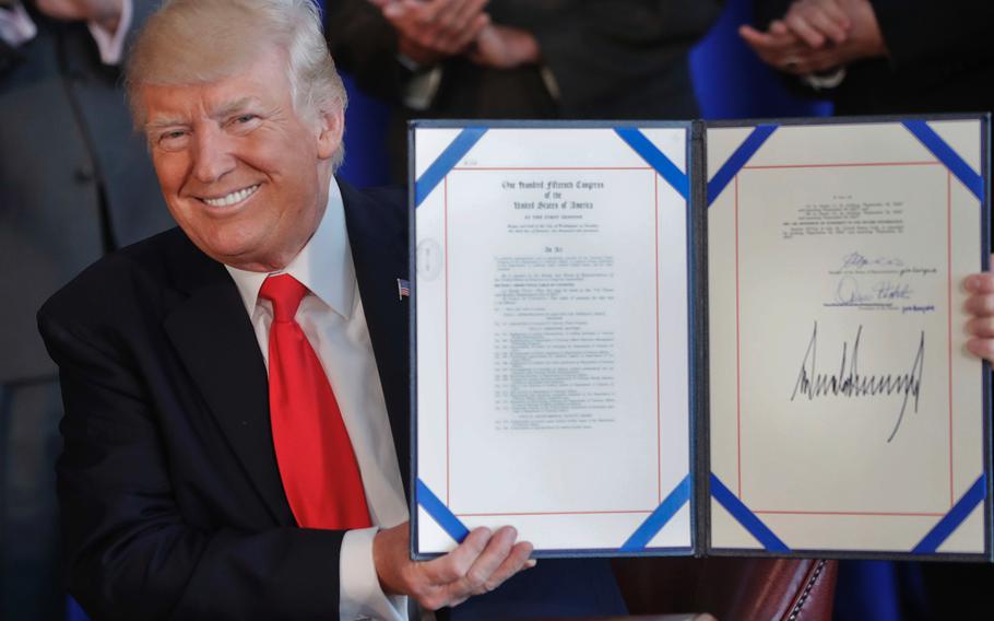 President Donald Trump smiles after signing the Veteran's Affairs Choice and Quality Employment Act of 2017 at Trump National Golf Club in Bedminister, N.J., Saturday, Aug. 12, 2017.