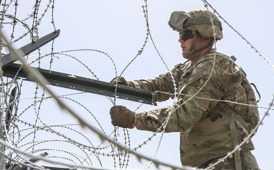 Soldiers from the 161st Engineer Support Company (Airborne) secure concertina wire to the existing border fence near the World Trade International Bridge in Laredo, Texas, April 11. The Department of Defense has deployed units across the Southwest Border at the request of U.S. Customs and Border Protection and is providing logistical, engineering, and force protection functions. (U.S. Army photo by Sgt. Andrew S. Valles)