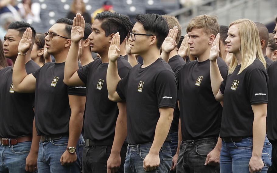 New Army recruits take part in a swearing-in ceremony before a baseball game between the San Diego Padres and the Colorado Rockies in San Diego. A year after failing to meet its enlistment goal for the first time in 13 years, the U.S. Army is now on track to meet a lower 2019 target after revamping its recruitment effort.