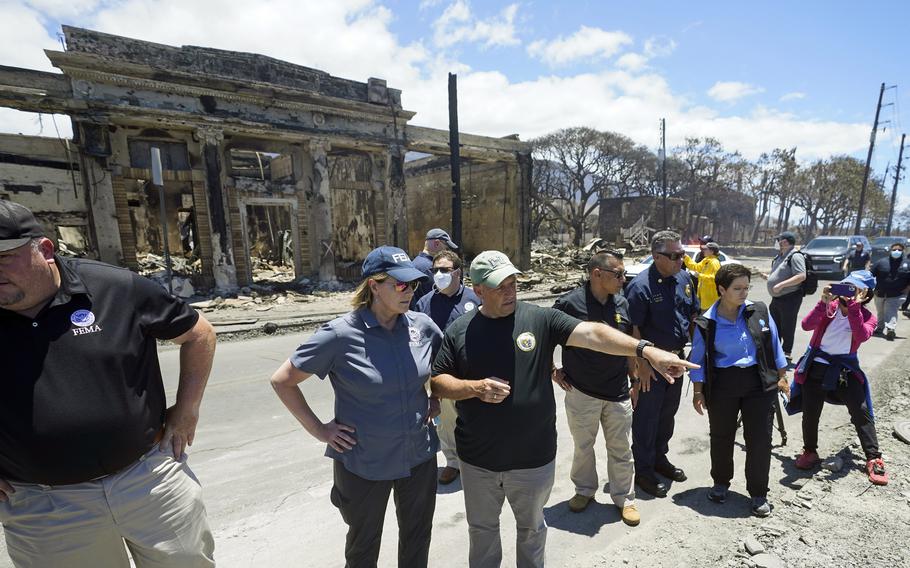 Hawaii Gov. Josh Green, center, points to damage as he speaks with Federal Emergency Management Agency Administrator Deanne Criswell during a tour of wildfire damage, Saturday, Aug. 12, 2023, in Lahaina, Hawaii.